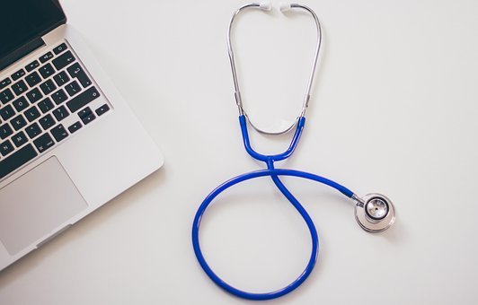 a shot of a stethoscope lying next to a laptop suggesting that cloud solutions help medical professionals